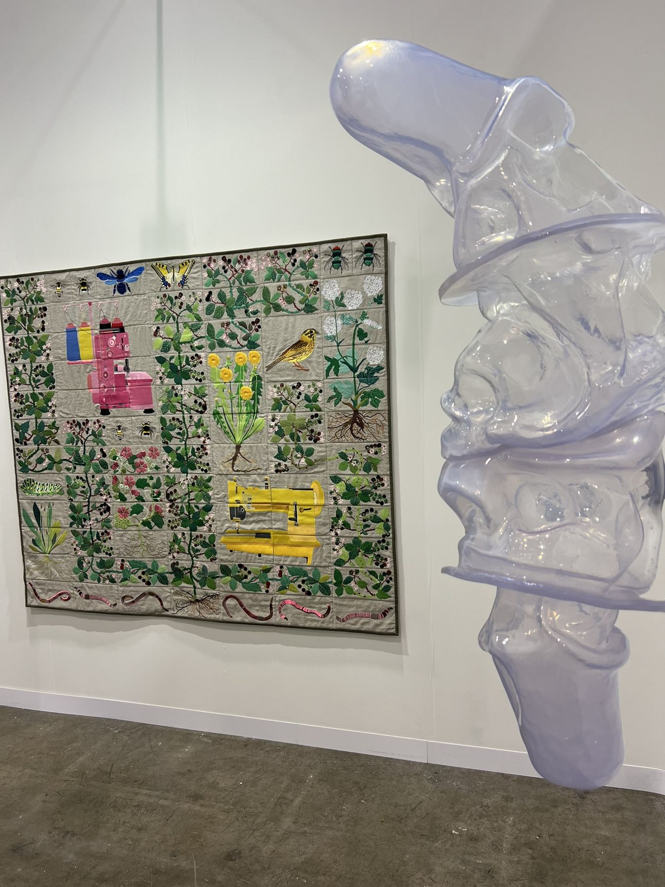 A translucent glass sculpture beside a richly patterned painting