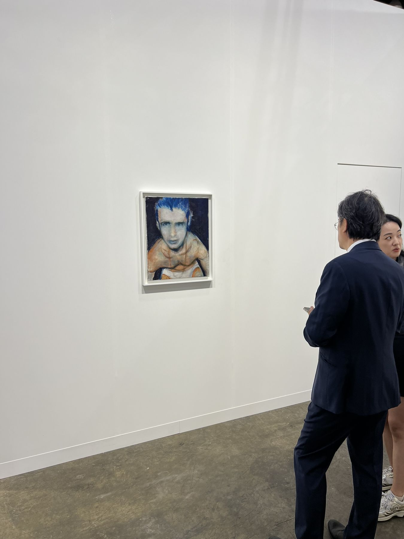 A collector looking closely at a small framed portrait