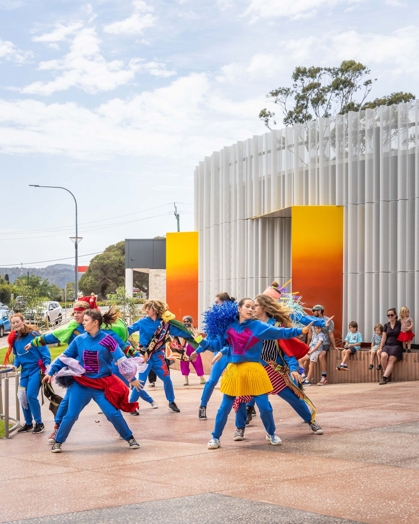 Performers in colourful costume outside SECCA