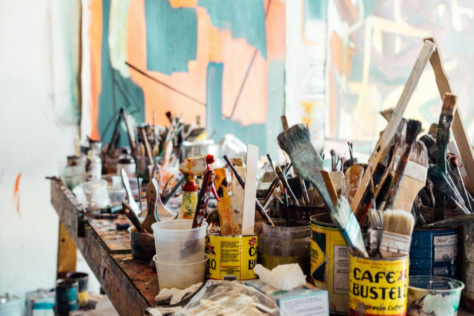 A studio bench crowded with brushes in tins